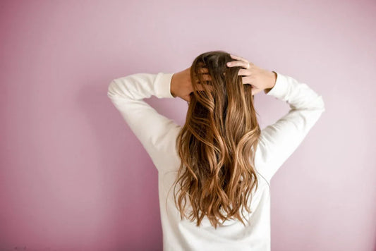 A girl showing her hairs after using oilbase organics nourishing hair oil